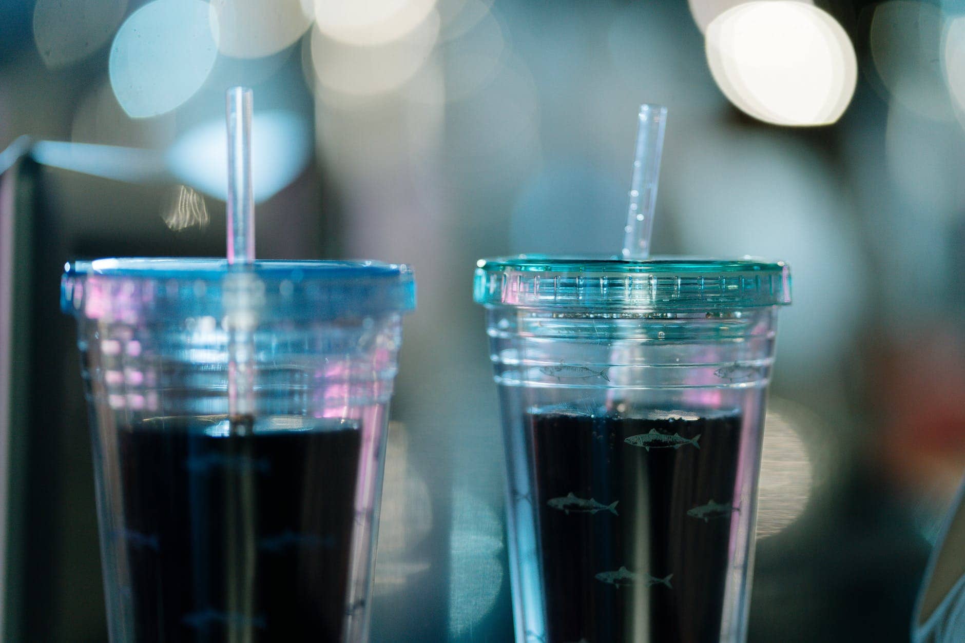 a couple of drinks in a clear disposable cups with straw
