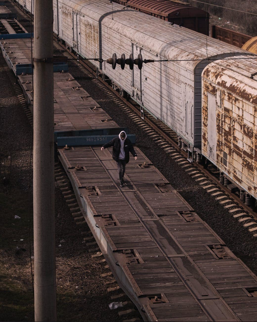 man in black jacket walking on train car platform