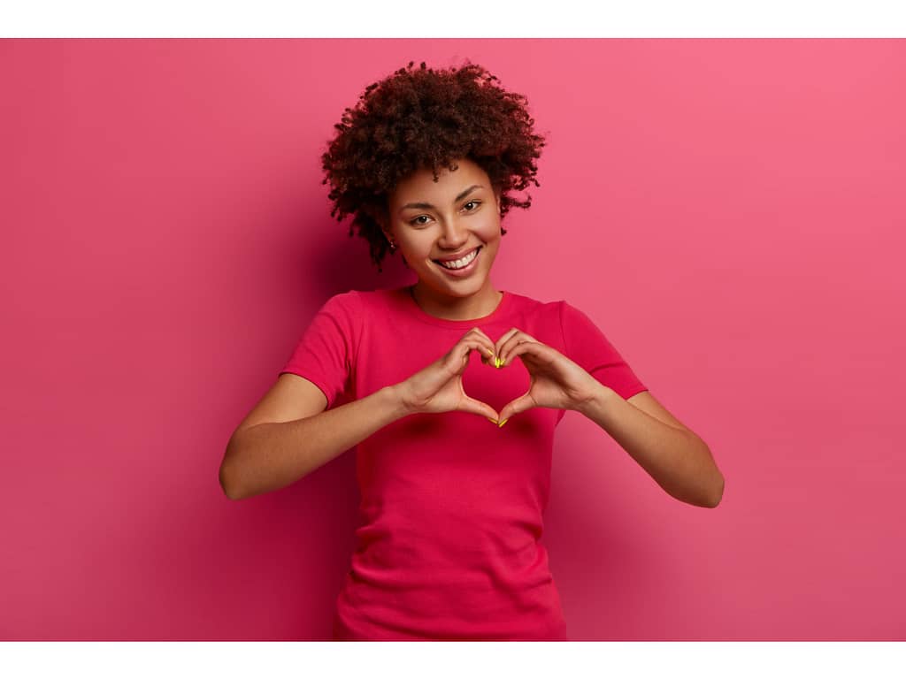 Woman making heart symbol with hands.